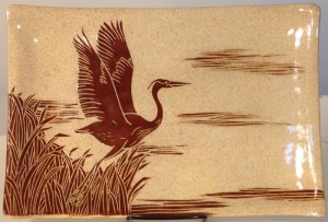 Stoneware platter, sgraffito carved heron in flight