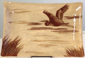 Stoneware platter, sgraffito carved heron in flight