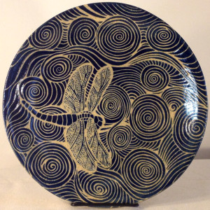 Round stoneware plate with sgraffito carved dragonfly and water motif