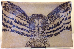 Stoneware platter, sgraffito carved great grey owl design