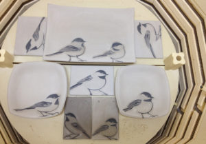 Kiln load of chickadee tiles and tableware, unfired